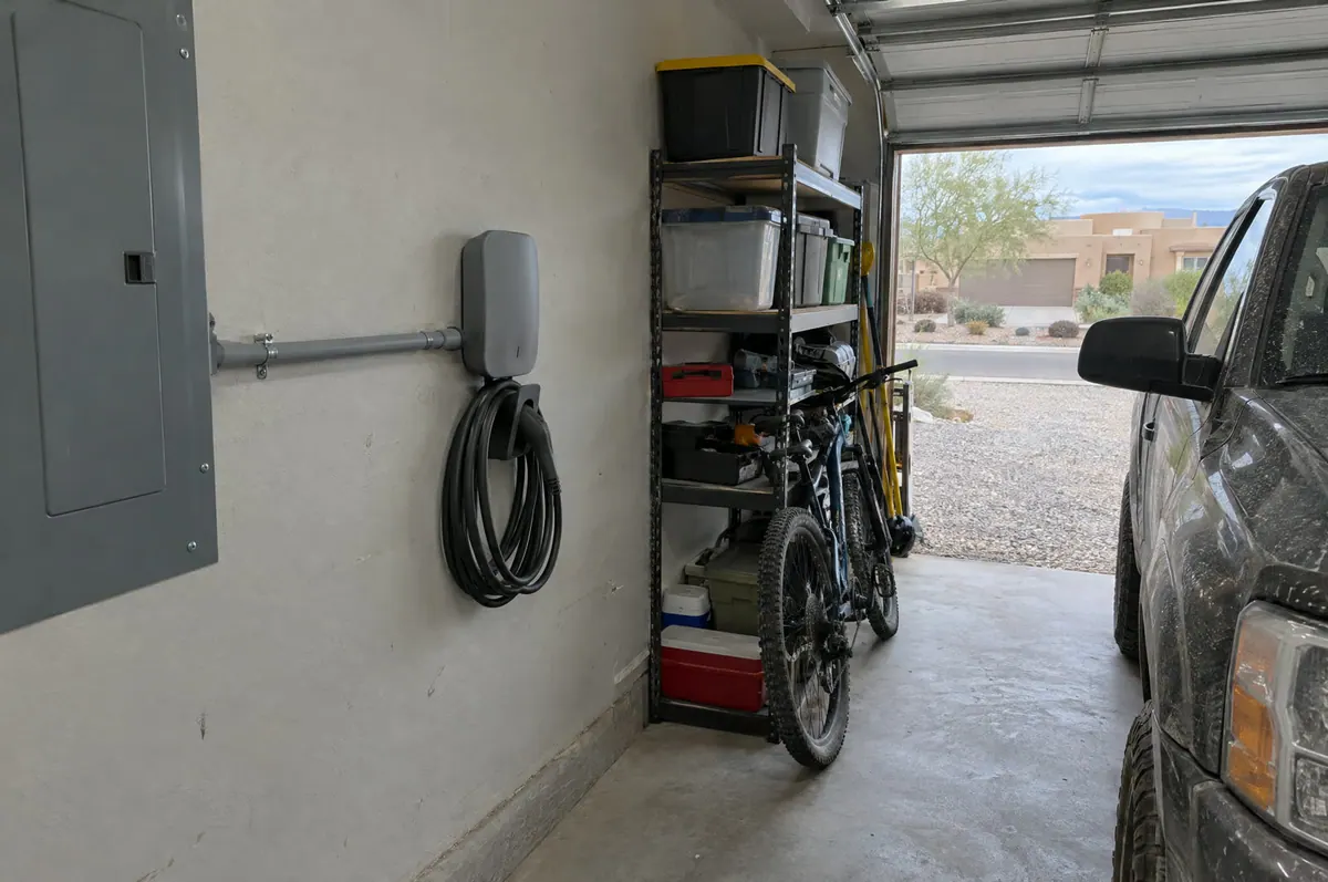 Wall-mounted Level 2 EV charger with conduit run in a home garage