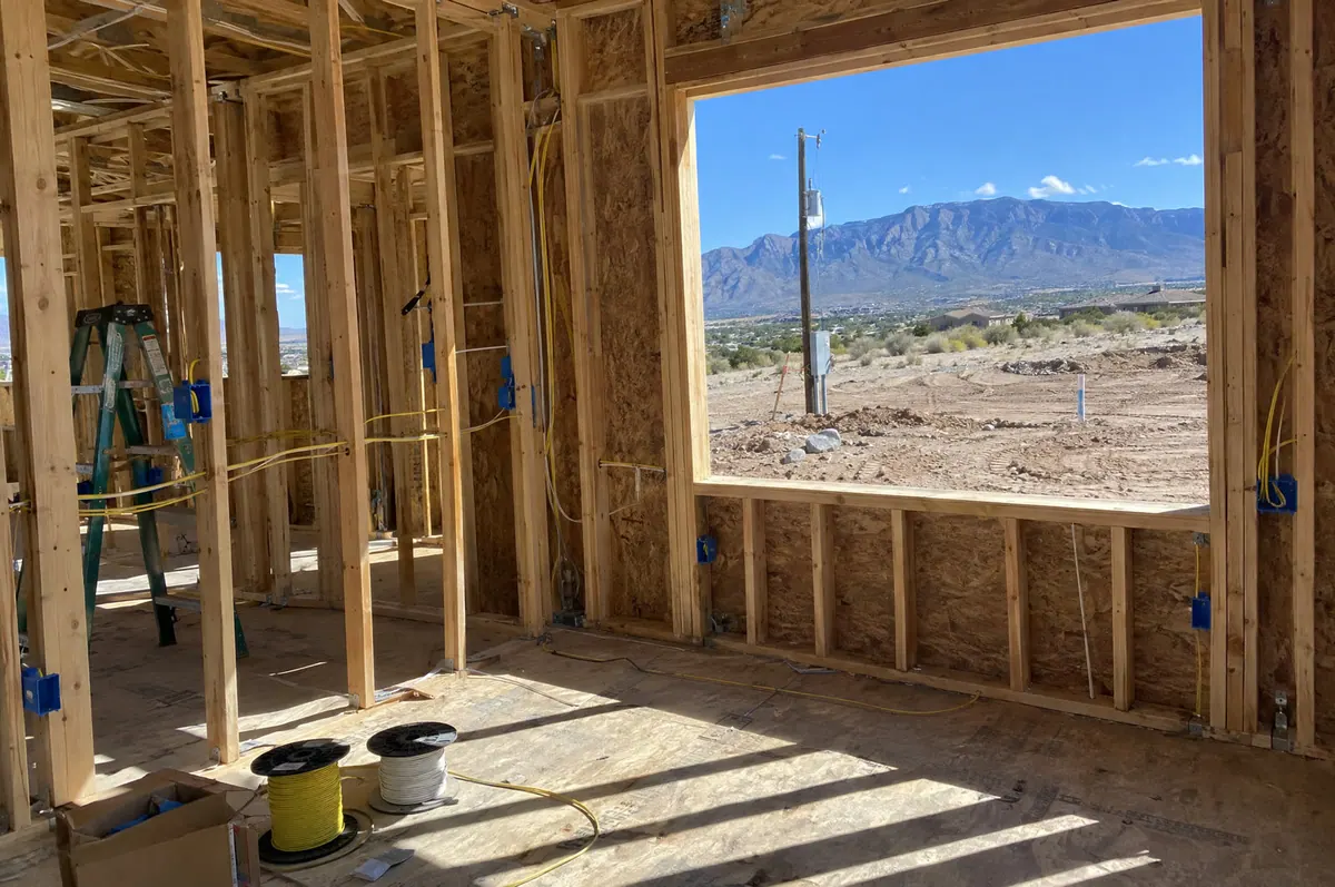 Electrical rough-in wiring in new home framing with the Sandia Mountains outside